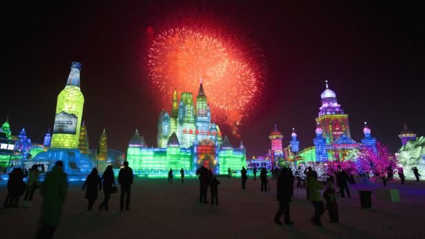 Feuerwerk über den farbenfrohen Eispalästen des Harbin International Ice and Snow Sculpture Festival.
