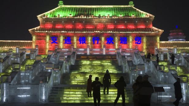 Eine Eisstruktur mit chinesischen Schriftzeichen und farbiger Beleuchtung in Harbin, China.