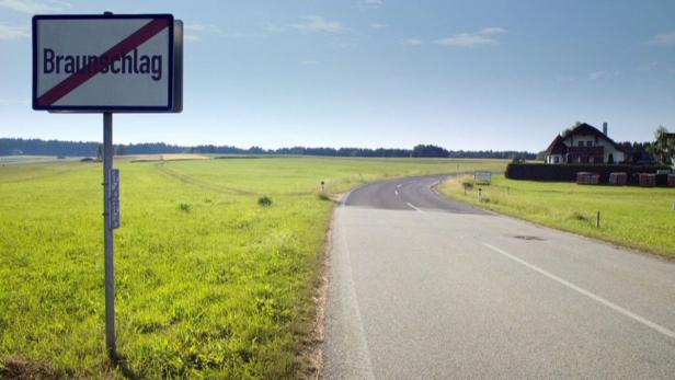 Ein Ortsschild von Braunschlag mit einem roten Strich darauf steht am Straßenrand.