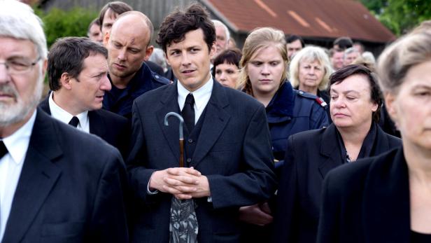 Eine Gruppe von Menschen in formeller Kleidung steht beieinander.