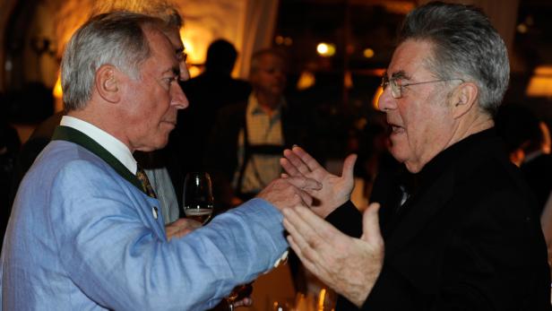 Zwei ältere Männer unterhalten sich angeregt auf einer Veranstaltung.