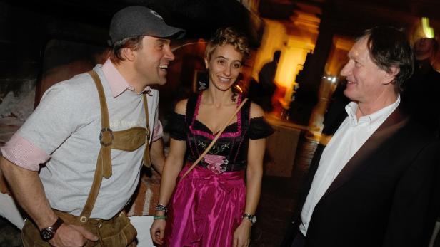 Drei Personen in Tracht unterhalten sich auf einer Veranstaltung.