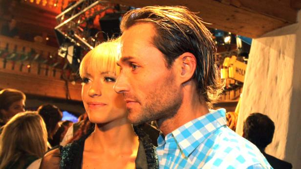 Ein Mann mit blonden Haaren und ein Mann mit blauem Hemd posieren für ein Foto.