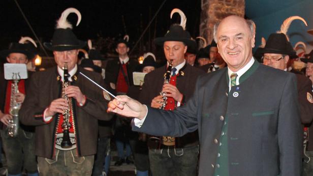 Ein Dirigent leitet eine Blaskapelle in Tracht.