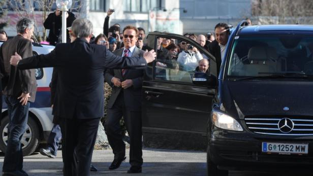 Arnold Schwarzenegger steigt aus einem schwarzen Mercedes-Van.