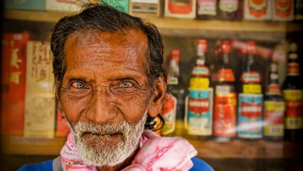 Ein älterer Mann mit Bart und einem Tuch um den Hals blickt in die Kamera.