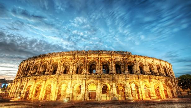 Das römische Amphitheater von Nîmes erstrahlt im Abendlicht.
