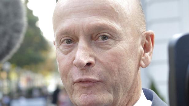 Nahaufnahme eines Mannes mit kurzem, hellem Haar vor unscharfem Hintergrund.