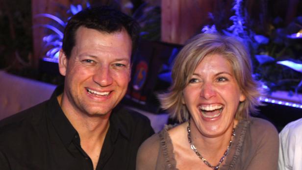 Ein lächelnder Mann und eine lachende Frau posieren für ein Foto.