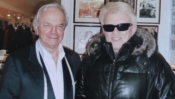 Zwei Männer posieren für ein Foto, einer mit einem Maßband um den Hals.