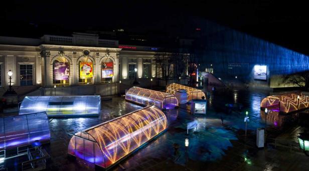 Nachts sind beleuchtete, tunnelartige Strukturen vor der Kunsthalle Wien zu sehen.