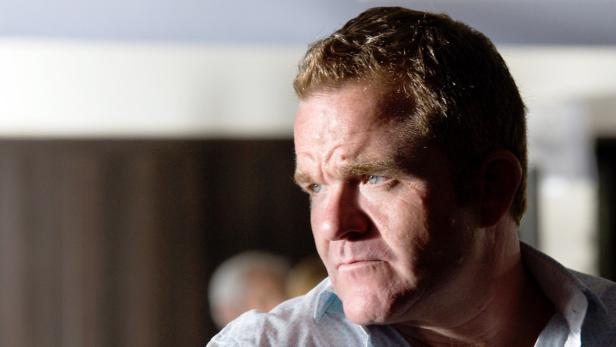 Ein Mann mit hellen Haaren und blauen Augen schaut nachdenklich zur Seite.