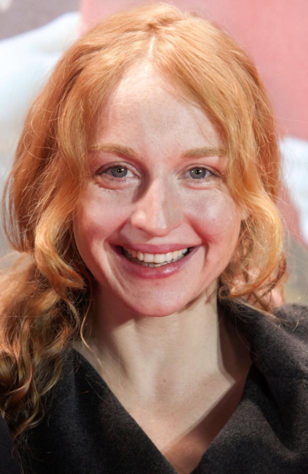 Eine lächelnde Frau mit roten Haaren und hellem Teint.