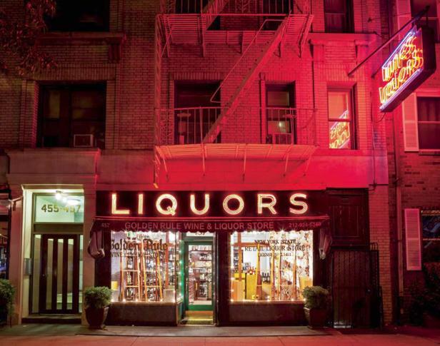 Ein Spirituosengeschäft namens „Golden Rule Wine & Liquor Store“ in einem Backsteingebäude mit Neonreklame.