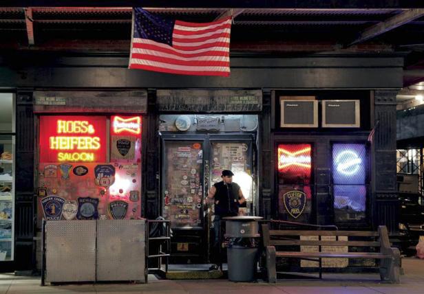 Die Fassade des „Hogs & Heifers Saloon“ mit Neonreklame und einer US-Flagge.