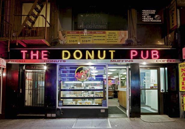 Die Fassade des „The Donut Pub“ mit Neonreklame in der Nacht.
