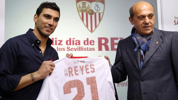 Zwei Männer halten ein Trikot mit dem Namen „Reyes“ und der Nummer 21.
