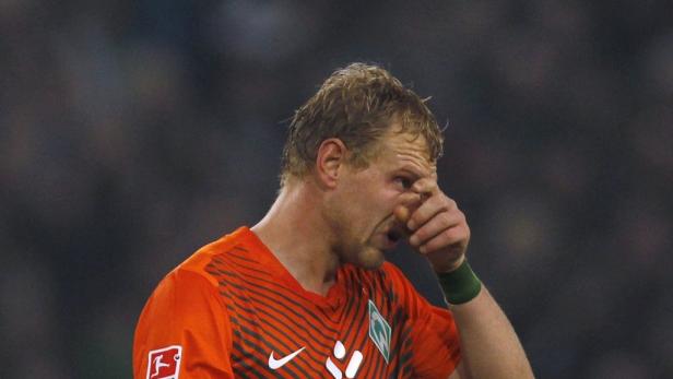 Ein Fußballspieler wischt sich den Schweiß aus dem Gesicht.