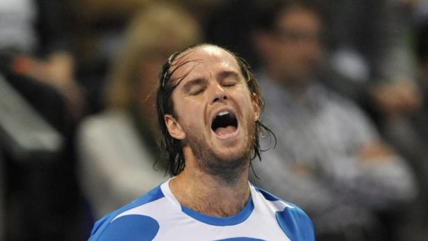 Ein Tennisspieler schreit mit geschlossenen Augen und nassem Haar.