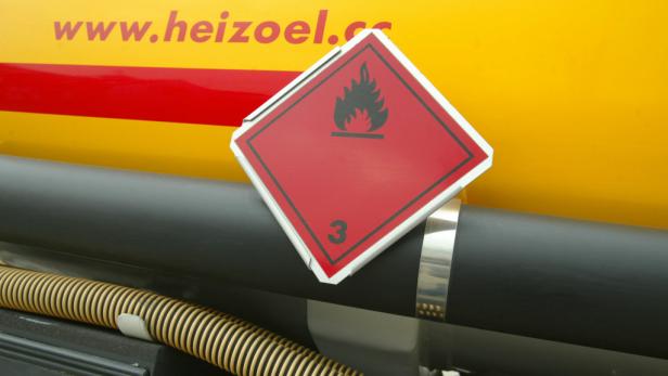 Ein Warnschild für entzündliche Flüssigkeiten an einem Tankwagen mit der Aufschrift „www.heizoel.cc“.