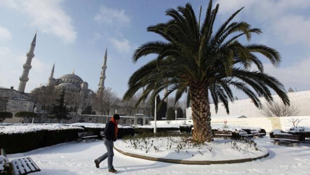 Ein Mann geht im Schnee vor der Sultan-Ahmed-Moschee in Istanbul entlang.