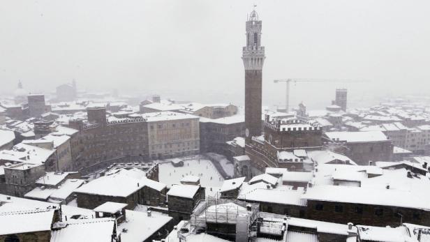 Blick auf das verschneite Siena mit dem Torre del Mangia im Zentrum.