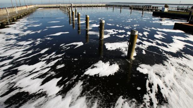 Ein gefrorener See mit Stegen und hölzernen Pfählen im Wasser.
