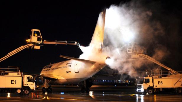 Ein Lufthansa-Flugzeug wird nachts enteist.