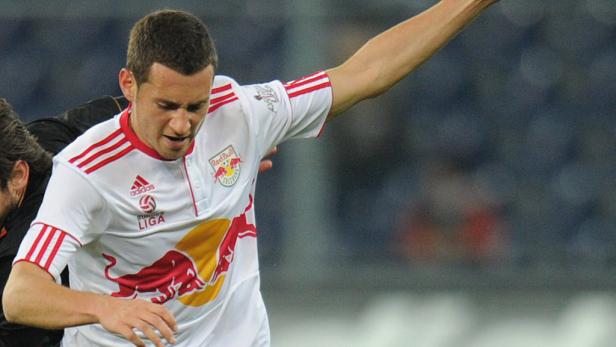 Ein Fußballspieler im Trikot von Red Bull Salzburg während eines Spiels.