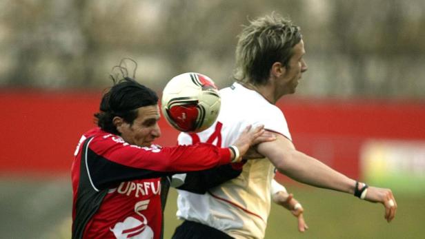 Zwei Fußballspieler kämpfen um den Ball.