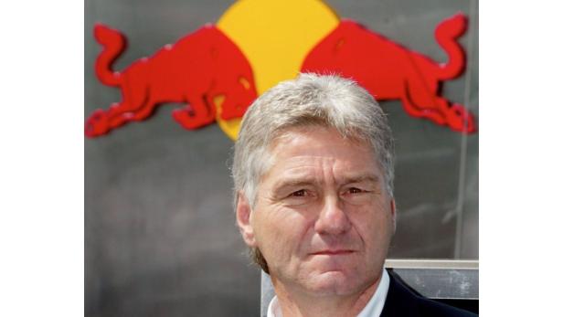 Ein Mann steht vor einem Red Bull Logo.