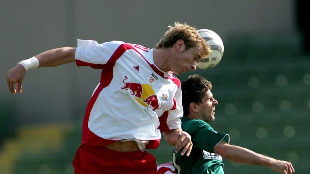 Zwei Fußballspieler kämpfen um den Ball in der Luft.