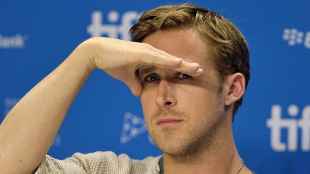 Ryan Gosling schirmt seine Augen mit der Hand ab.