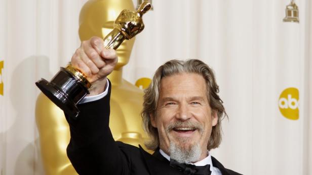 Jeff Bridges hält eine Oscar-Statue in die Höhe.