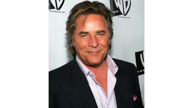 Porträt von Don Johnson in einem dunklen Anzug und hellblauem Hemd.