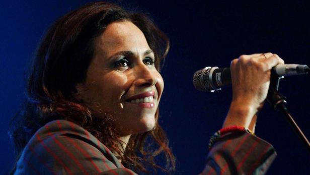 Eine Frau singt mit einem Mikrofon in der Hand.