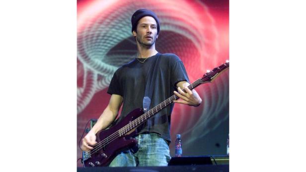 Keanu Reeves spielt Bass auf einer Bühne.
