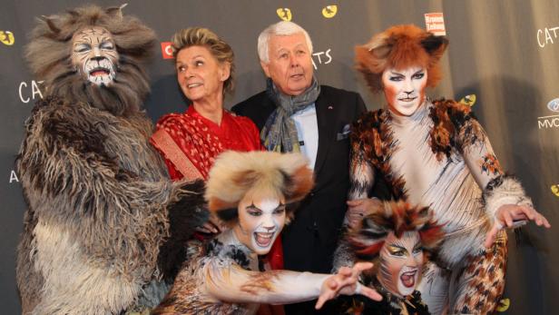 Ensemblemitglieder der „Cats“-Produktion posieren mit zwei älteren Gästen für ein Foto.