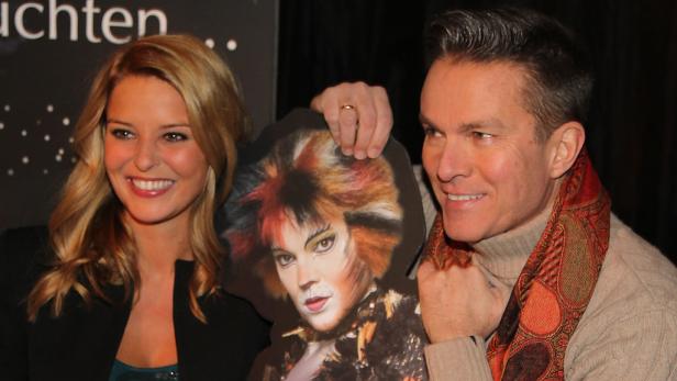 Zwei Personen posieren mit einem Aufsteller der Katze aus dem Musical „Cats“.