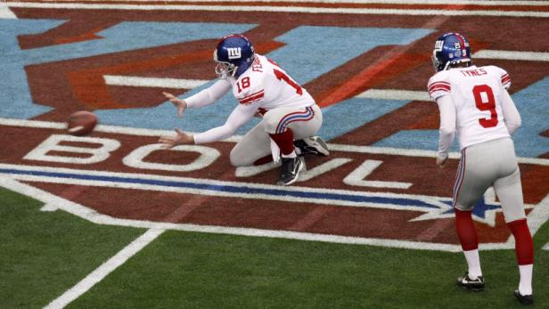 Ein Footballspieler der New York Giants kniet und fängt einen Football.