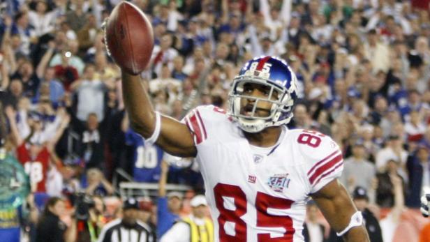 Ein Footballspieler der New York Giants hält einen Football in die Höhe.