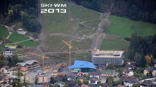 Blick auf eine Baustelle in einem Skiort mit der Aufschrift „SKI-WM 2013“ am Hang.