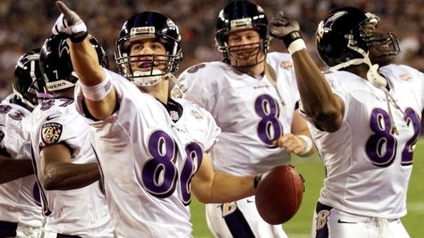 Mehrere Footballspieler der Baltimore Ravens jubeln auf dem Feld.