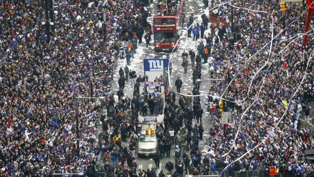 Eine Parade für die New York Giants mit jubelnden Menschenmassen und Konfetti.