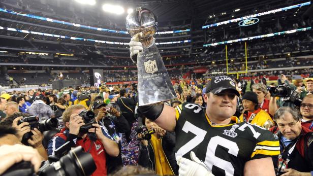 Ein Footballspieler der Green Bay Packers hält die Vince Lombardi Trophy hoch.