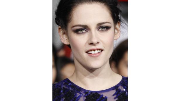 Nahaufnahme von Kristen Stewart mit dunklem Augen-Make-up und einem blauen Kleid.