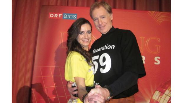 Ein Mann und eine Frau posieren vor einem roten Hintergrund mit dem ORF-Logo.