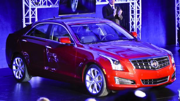 Ein roter Cadillac steht auf einer Bühne unter blauem Licht.