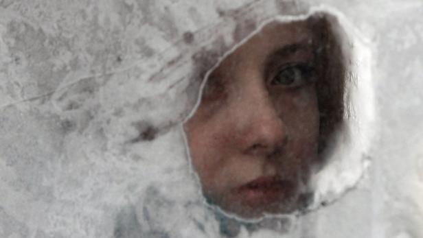 Das Gesicht einer Person ist durch eine frostige Oberfläche zu sehen.