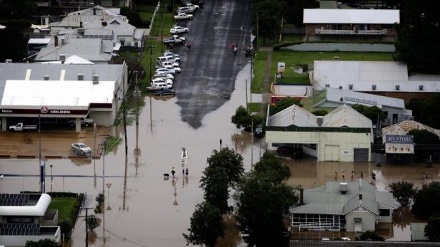 Überschwemmungen haben eine Stadt heimgesucht, Häuser und Straßen stehen unter Wasser.